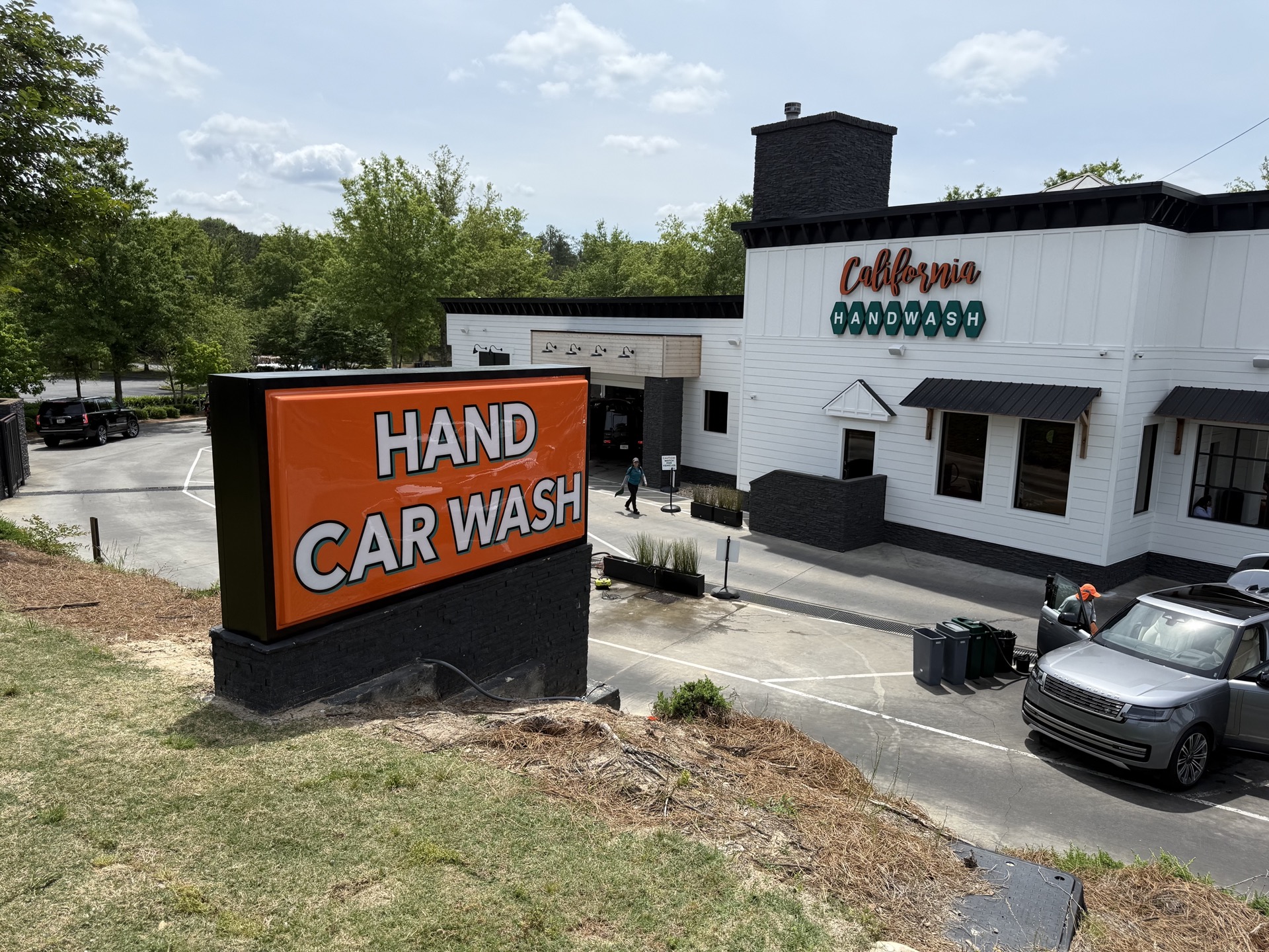 Street view of the California Hand Wash monument sign, catching the eye of passing traffic with sleek design and bold lettering.