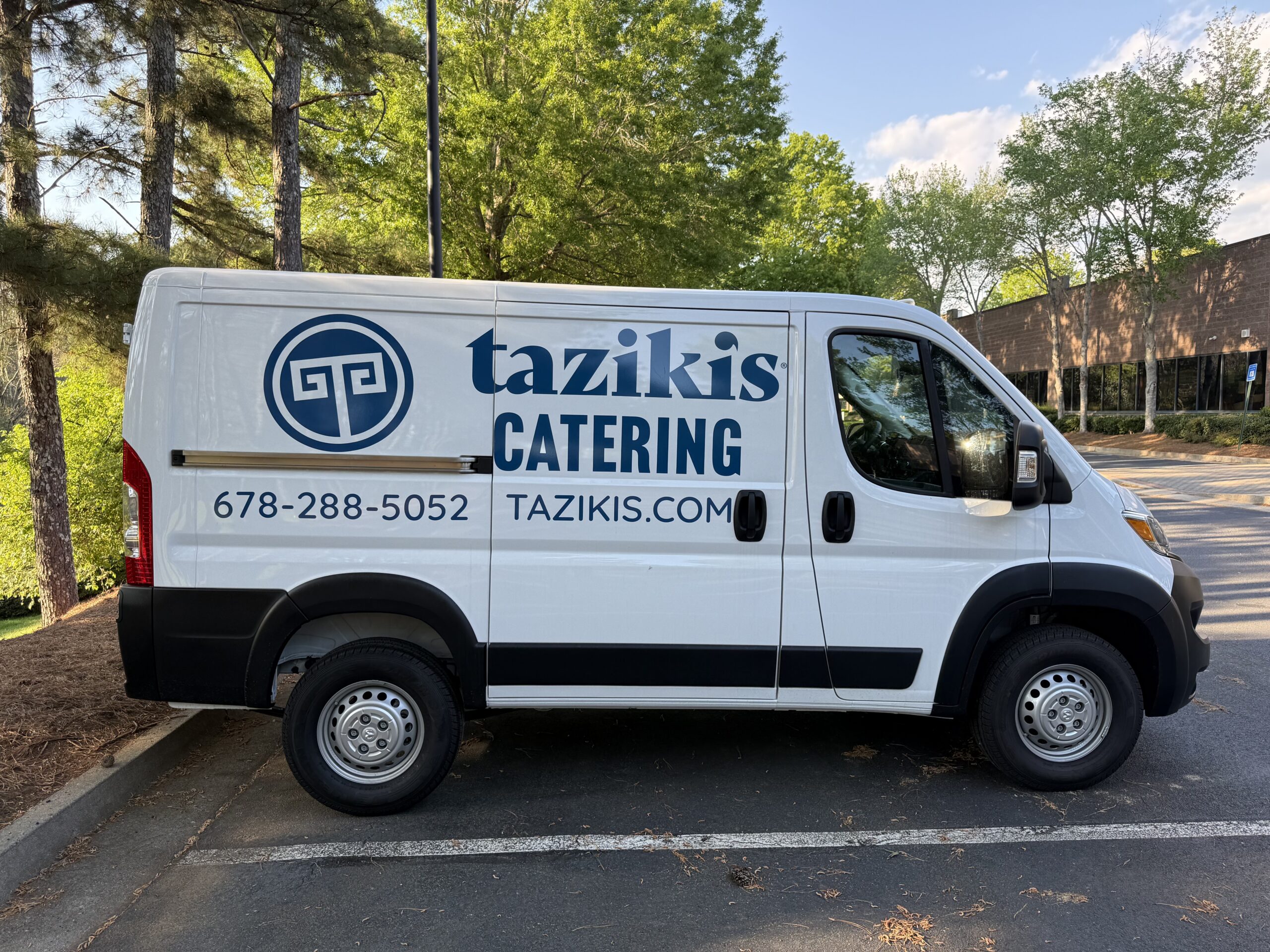 Catering van for Taziki&rsquo;s in Johns Creek, GA featuring spot graphics and vinyl lettering on the sides for clear, on-the-road branding.